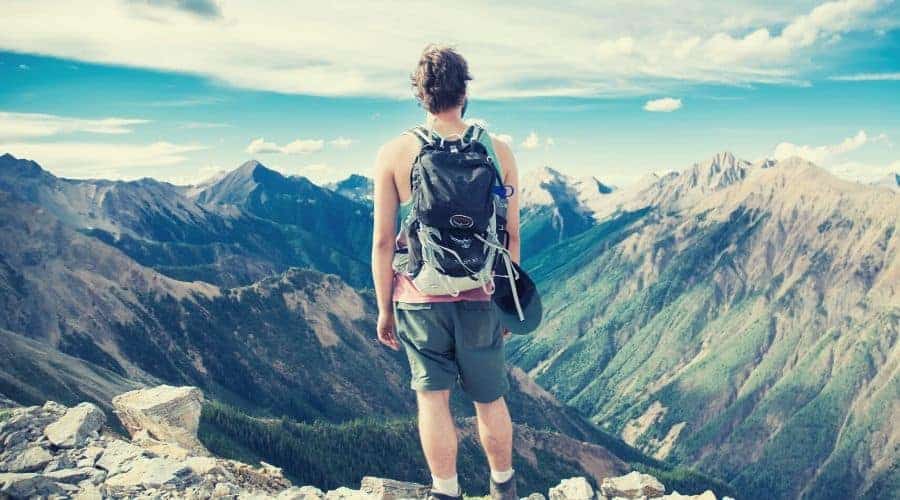 hiker overlooking mountainous valley panorama