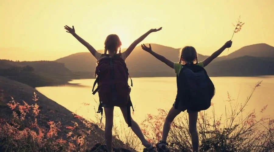 silhoutte di due ragazze che fanno escursioni sul lago