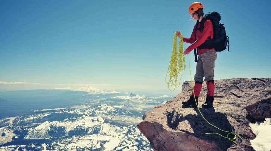 woman preparing rope on mountain ledge