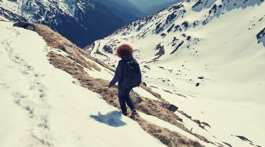 women hiking along snowy pass
