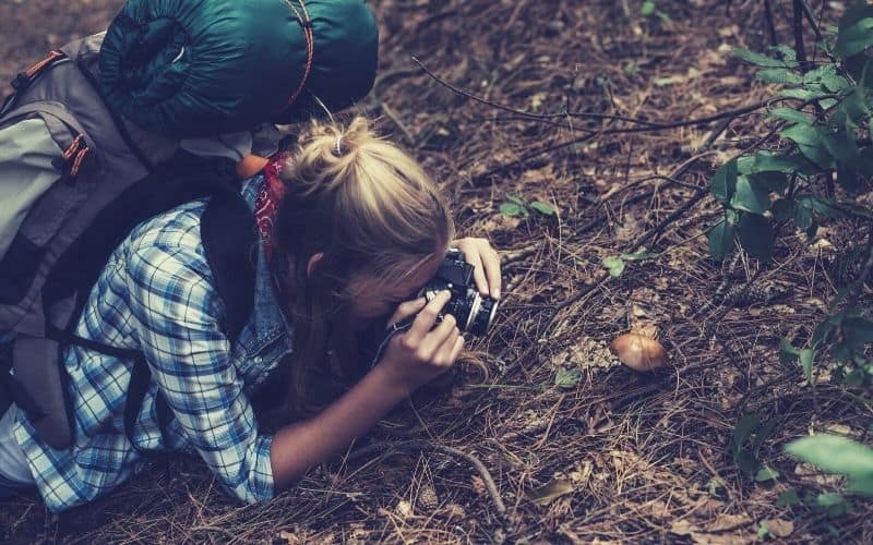 backpacker photographing mushroom