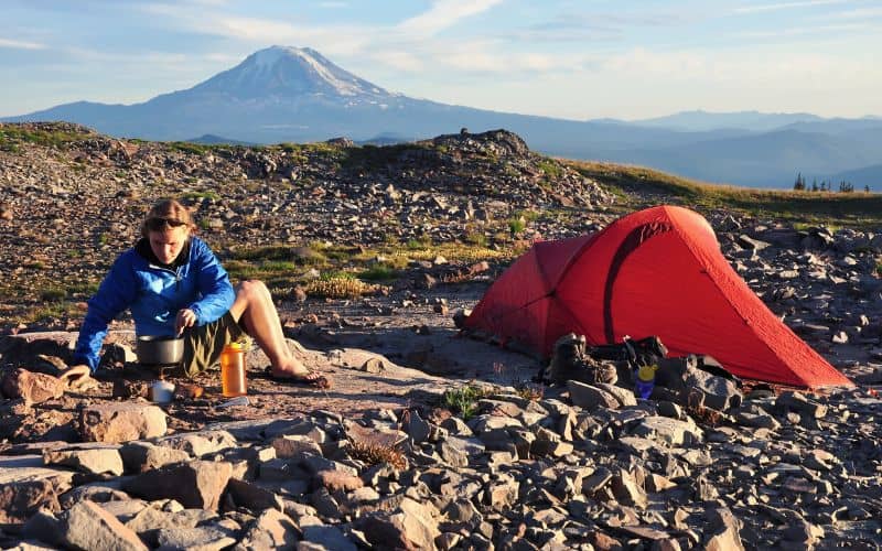 Woman camped in front of a mountain