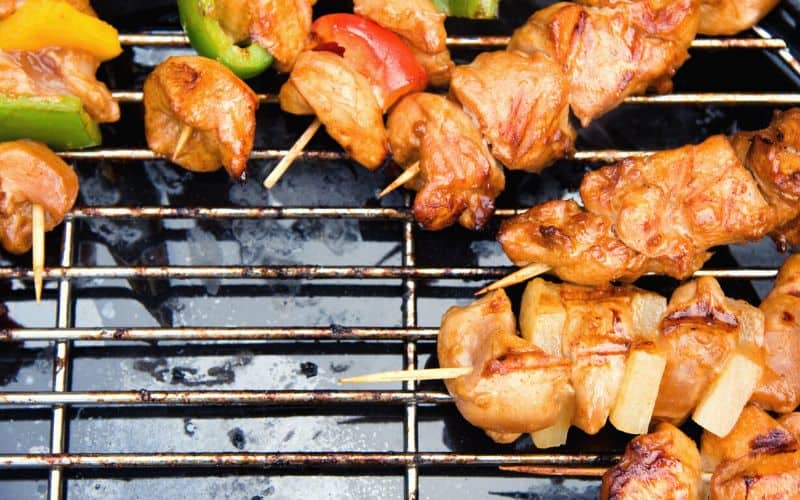 Chicken and pineapple and chicken and pepper kebabs on grill